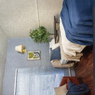 A cozy bedroom with blue-themed decor and natural light from a window.
