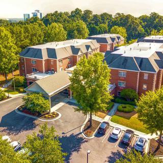 Aerial view of a suburban residential area with brick buildings and surrounding trees.