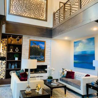 A modern, luxurious living room featuring contemporary furniture and vibrant artwork.