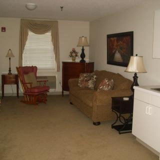 A cozy living room with a sofa, armchair, and decorative lamps.
