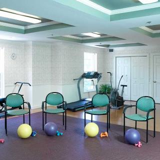 A small gym room with exercise equipment and seating.