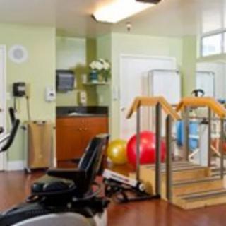 A physical therapy room equipped with various rehabilitation machines and exercise tools.