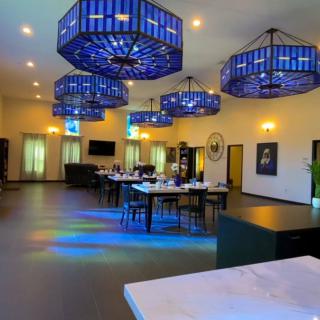 A modern restaurant interior with elegant blue chandeliers and a spacious dining area.