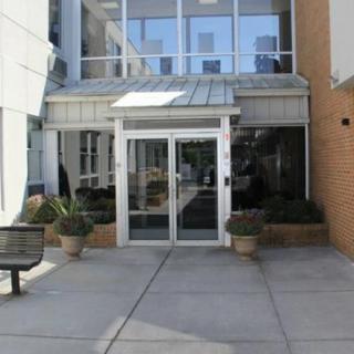 A modern building entrance with glass doors and potted plants.