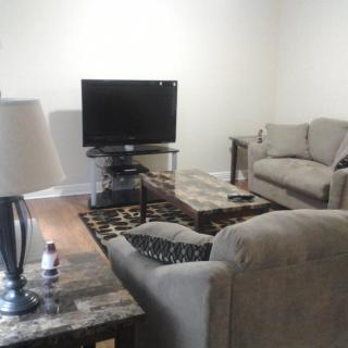 A cozy living room with a sofa set, television, and coffee table.