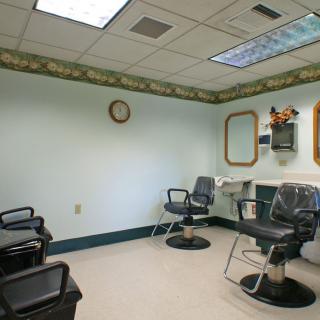 An empty barbershop with chairs and mirrors, ready for customers.