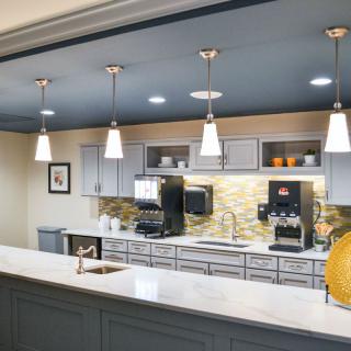 A modern kitchen with stylish pendant lighting, featuring sleek countertops and appliances.
