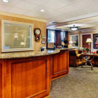 Reception area of an office with a wooden desk and comfortable seating.