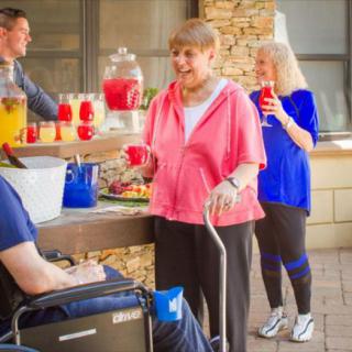 A group of elderly people enjoying an outdoor gathering with refreshments.