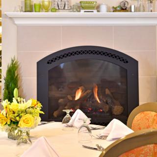 Elegant dining area with a cozy fireplace and a beautifully set table.
