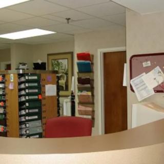 A reception area with seating and display racks filled with brochures.