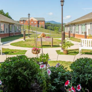 A serene garden with flower beds and walkways between buildings.