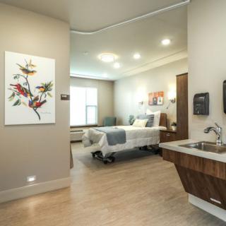 A modern hospital patient room with a comfortable bed and contemporary interior design.