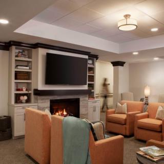 A cozy living room featuring a fireplace, television, and comfortable seating.