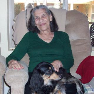 A woman sitting comfortably in a chair with her dog.