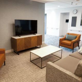 A modern living room with a television, comfortable seating, and sleek furniture.