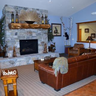 A cozy living room with a rustic stone fireplace and leather furniture.
