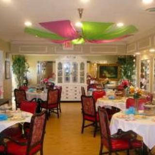 A well-decorated dining room with colorful ceiling drapery and elegantly set tables.