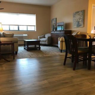 A cozy living room with a sofa, coffee table, and dining area.