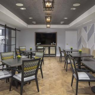 A modern dining area with stylish tables and chairs, featuring elegant lighting fixtures.