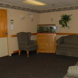 A quiet waiting room with chairs, a sofa, and an aquarium.