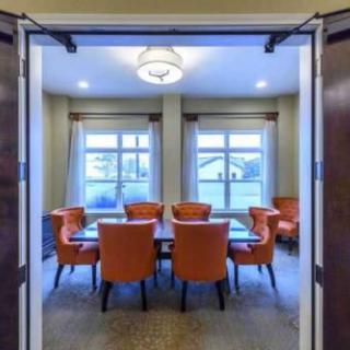 A well-lit conference room with orange chairs and a central table.