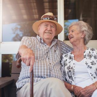 A joyful moment shared between an elderly couple enjoying each other's company outdoors.
