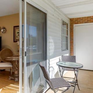 A cozy patio featuring a small table and chairs next to a sliding glass door.