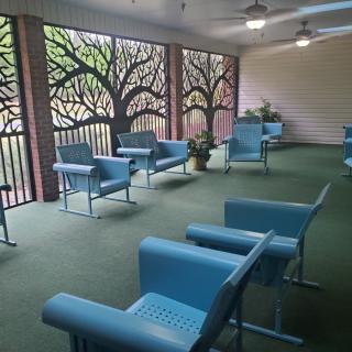 A modern waiting area featuring blue chairs and decorative wall panels.