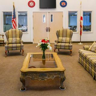 A cozy lobby with patterned armchairs, a coffee table, and American flags.