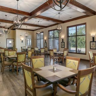 A modern dining area with wooden beams, ample seating, and natural lighting.