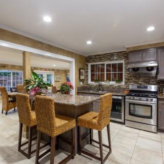Modern kitchen with island seating and stainless steel appliances in an open layout.
