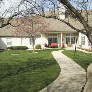 A suburban house with a well-maintained lawn and a winding pathway.