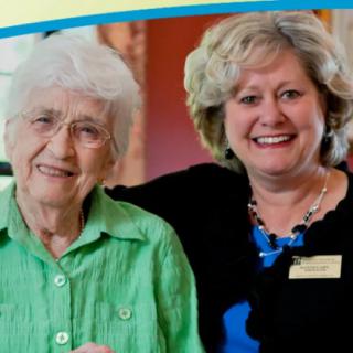 Two women smiling together indoors.