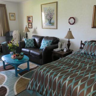 A cozy room featuring a bed, sofa, and coffee table with coordinated decor.