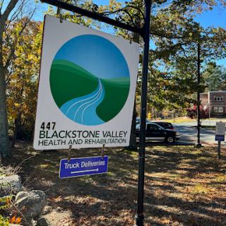 Sign for Blackstone Valley Health and Wellness Center, set in a picturesque outdoor setting.