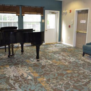 A cozy room featuring a grand piano and comfortable seating.