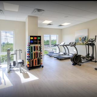 A well-lit gym featuring treadmills and various exercise equipment.