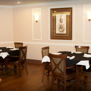 A cozy restaurant dining area with elegantly set tables and chairs.