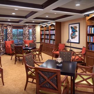 A cozy library with bookshelves, tables, and comfortable seating.