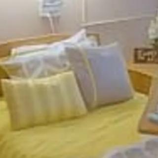 A cozy bed with neatly arranged pillows in a warmly lit bedroom.