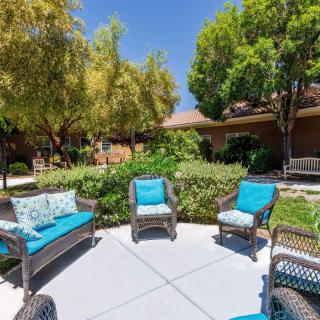 A serene outdoor patio area with wicker furniture and lush greenery.