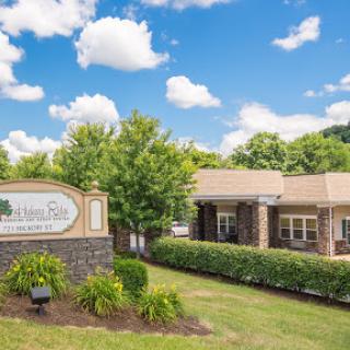 A scenic view of a well-maintained commercial building with clear blue skies and decorative landscaping.