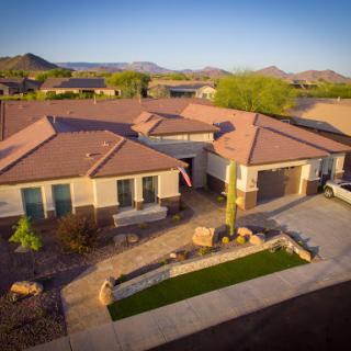 A beautiful suburban home surrounded by mountains, showcasing a well-maintained exterior and landscaping.