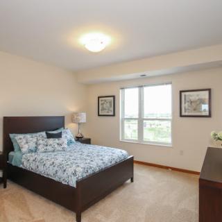 A cozy and well-decorated bedroom featuring a comfortable bed, natural light, and inviting decor.
