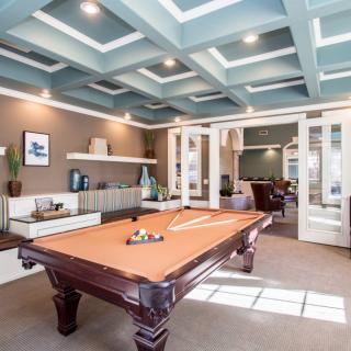 A stylish billiards room featuring a pool table and modern interior design.