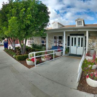 A welcoming entrance to a beautifully landscaped building on a cloudy day.