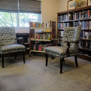 A cozy reading area with chairs and bookshelves in a library.