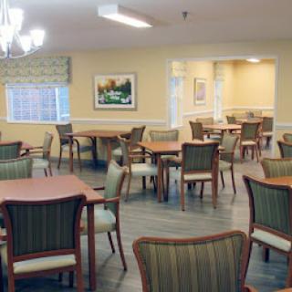A cozy dining area featuring wooden tables and comfortable chairs, designed for community gatherings.