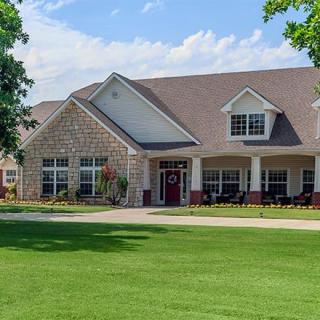A suburban house with a well-maintained lawn and brick exterior.